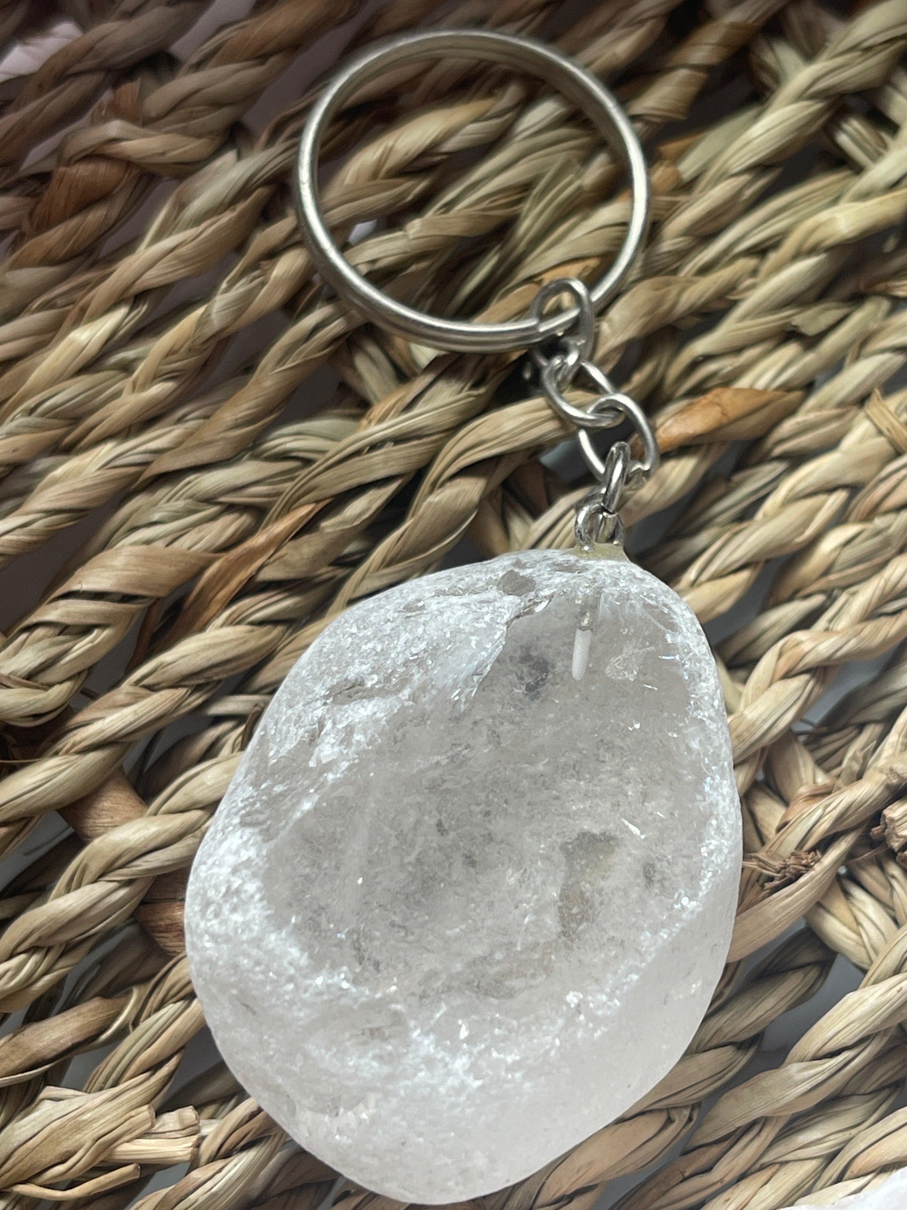 Clear Ema Egg Seer Stone Polished Keychain stone keychain on a woven mat