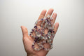 Hand holding a stack of multicolored crystal necklace 