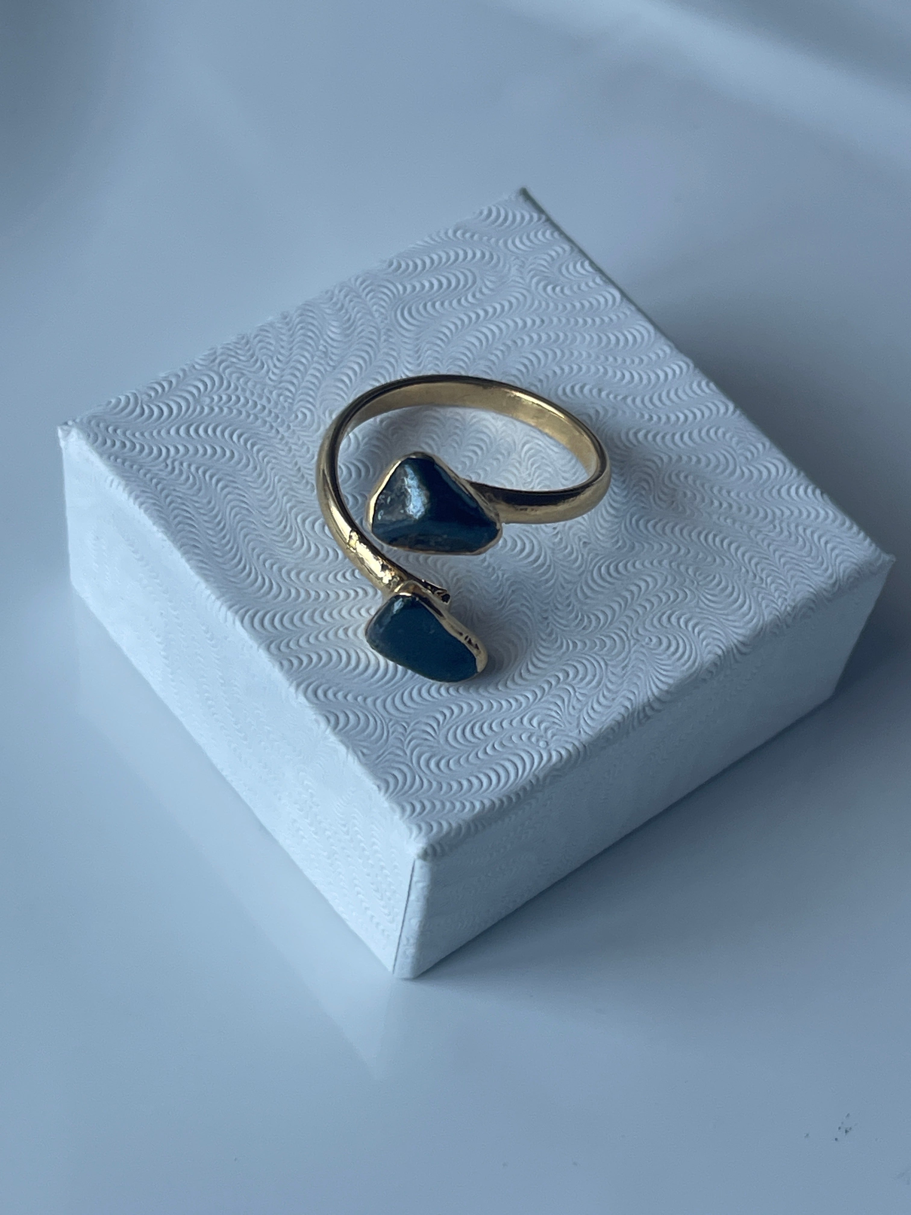 Hematite Adjustable Ring Gold Plated on a jewelry box top