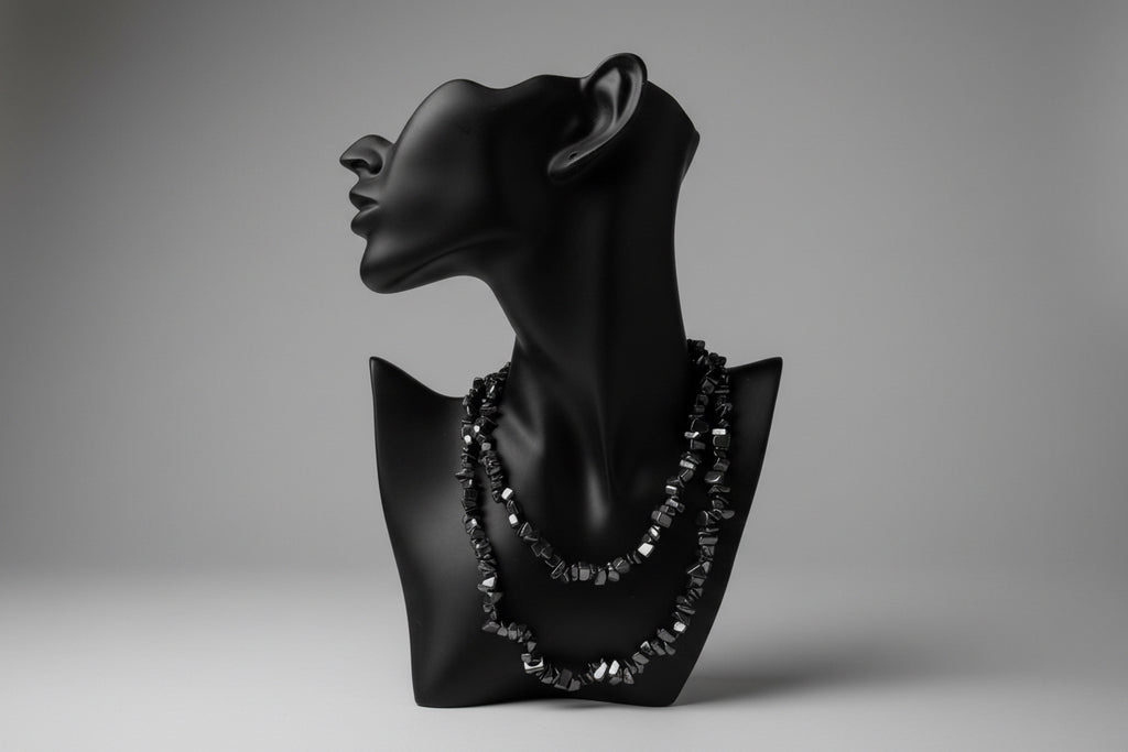 Black jewelry display with Hematite necklace and a gray backdrop 