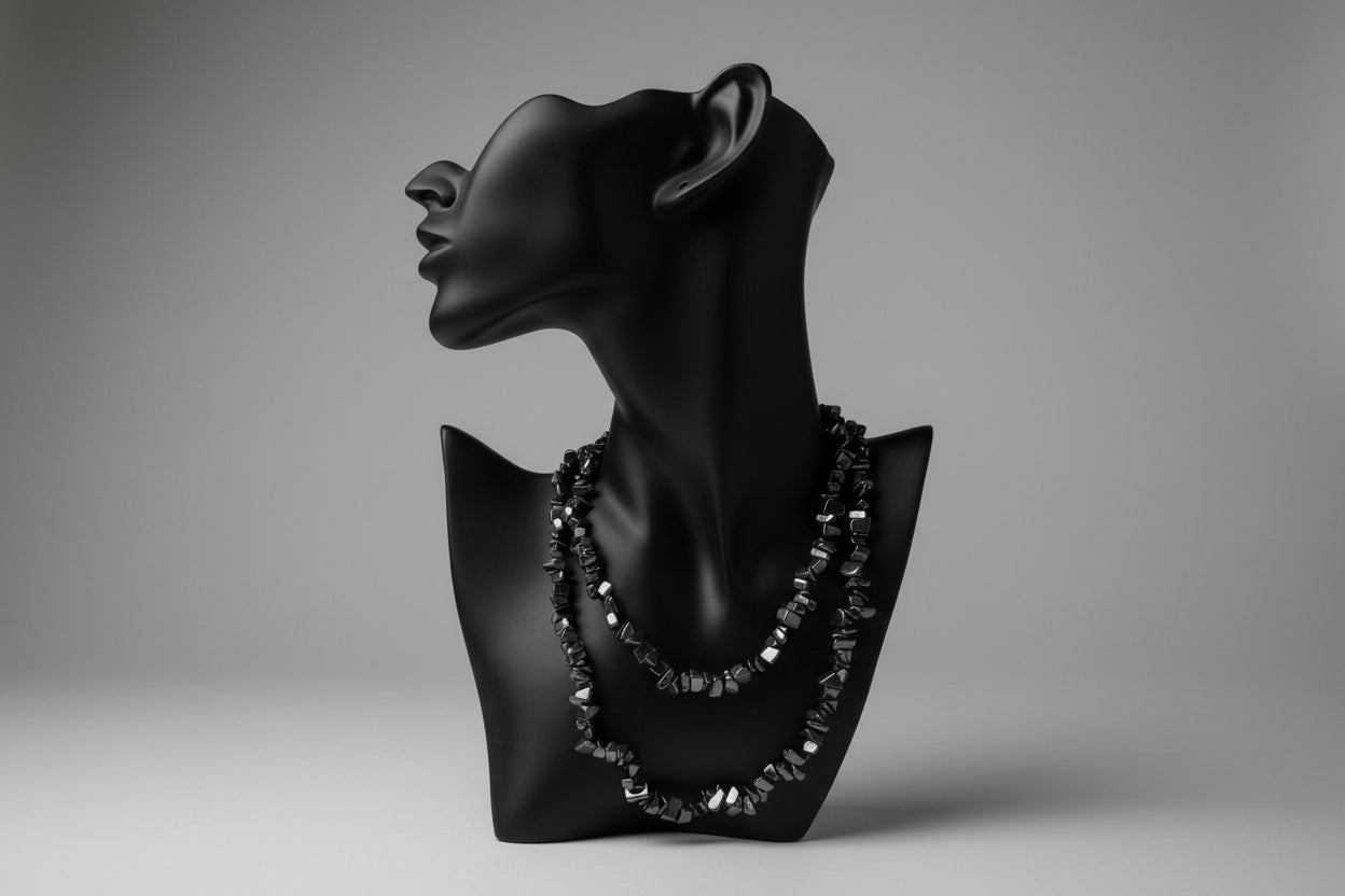 Black jewelry display with Hematite necklace and a gray backdrop 