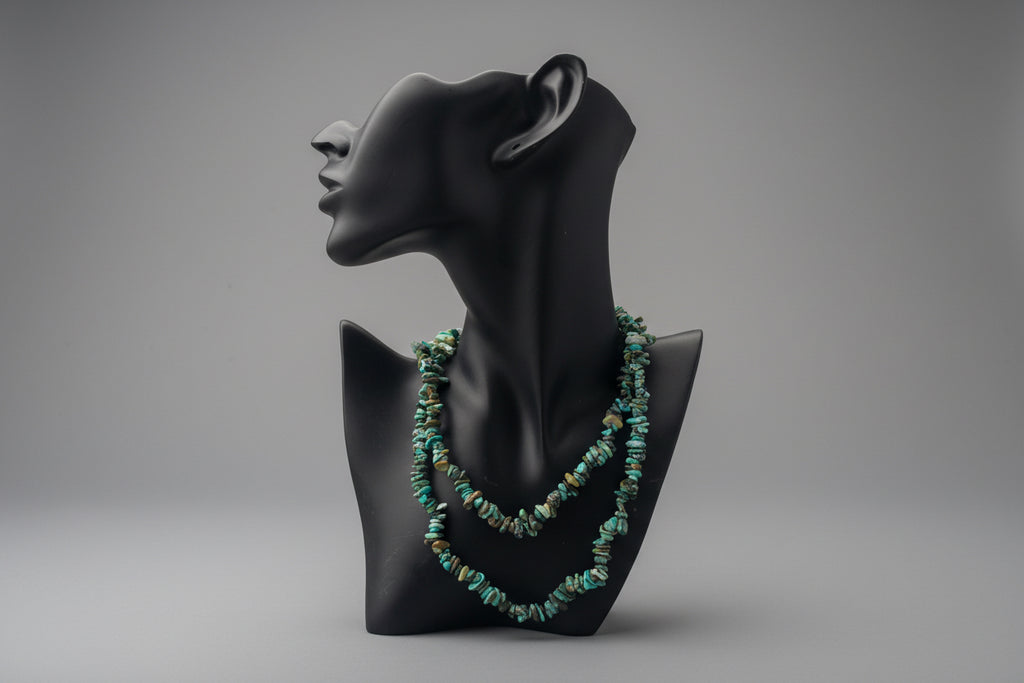 Black display with a green beaded Hubei_Turquoise_Necklace_30-32_Inches necklace in front of a gray backdrop. 
