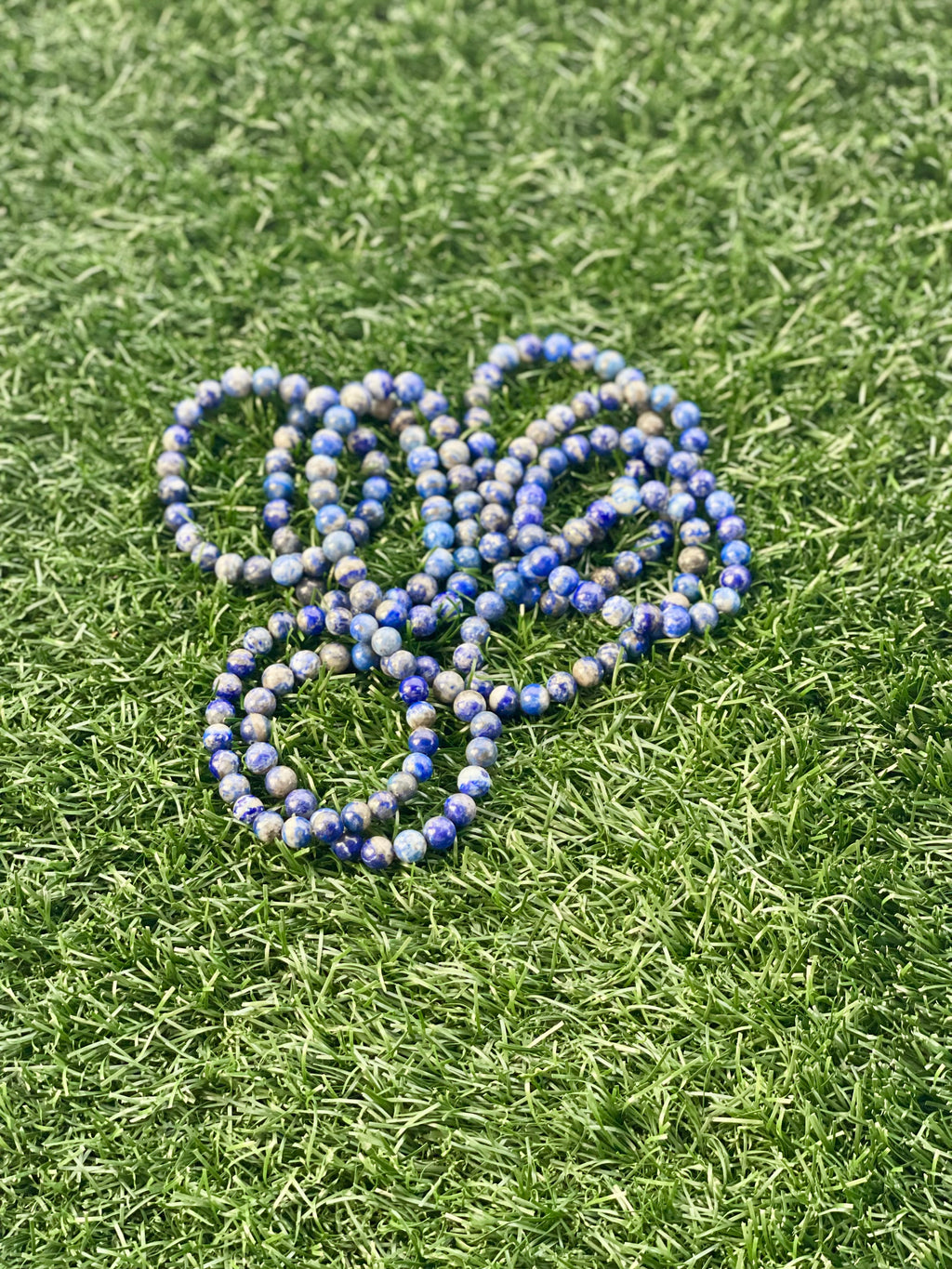 Blue and white beaded bracelet on green grass