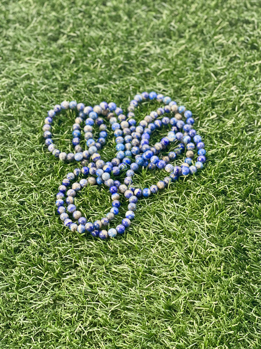 Blue and white beaded bracelet on green grass
