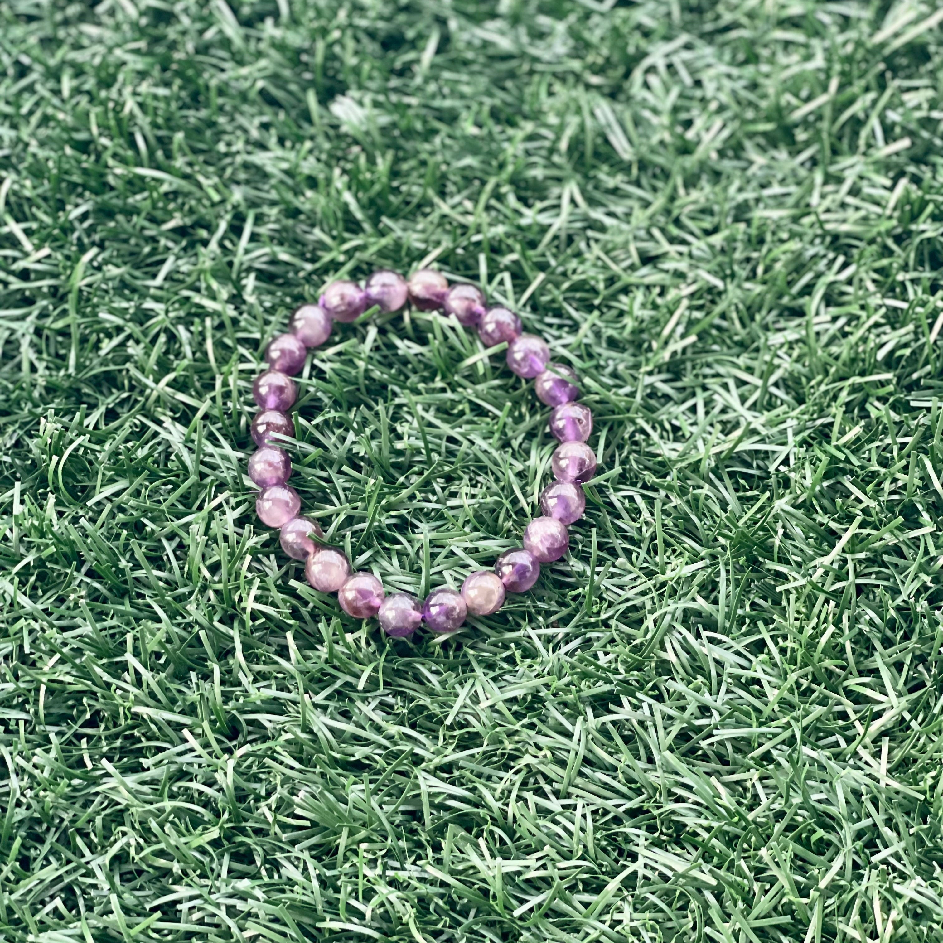 Purple beaded bracelet on green grass