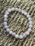 Pink beaded bracelet on a woven surface Kunzite Bracelet Florida at Pure Energy Crystals 