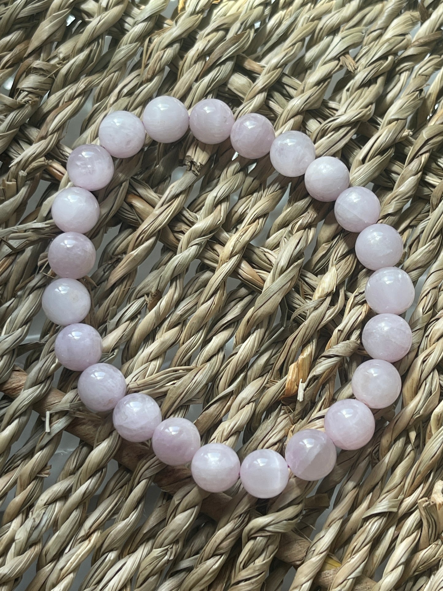 Pink beaded bracelet on a woven surface Kunzite Bracelet Florida at Pure Energy Crystals 