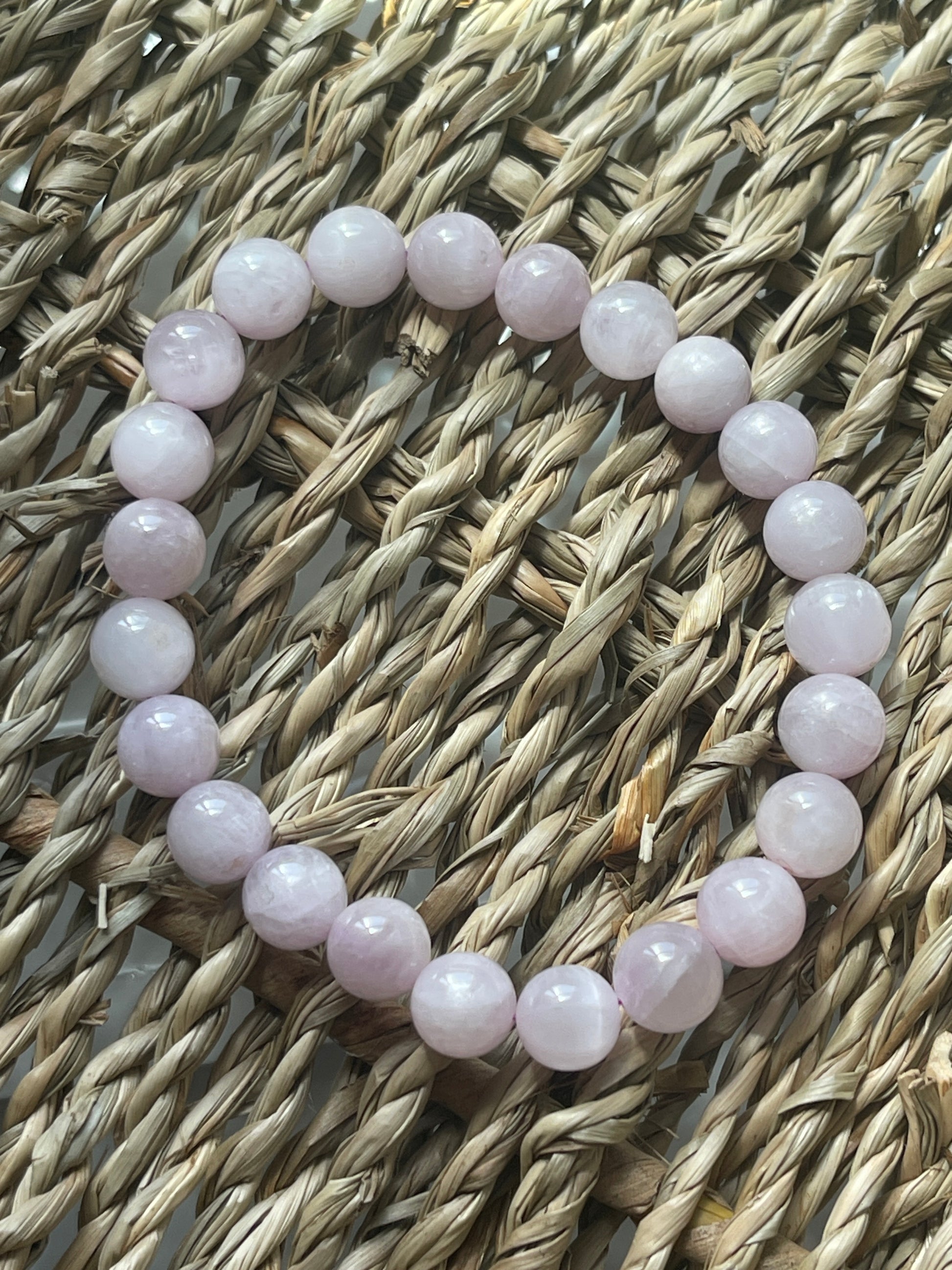 Pink beaded bracelet on a woven surface Kunzite Bracelet Florida at Pure Energy Crystals 