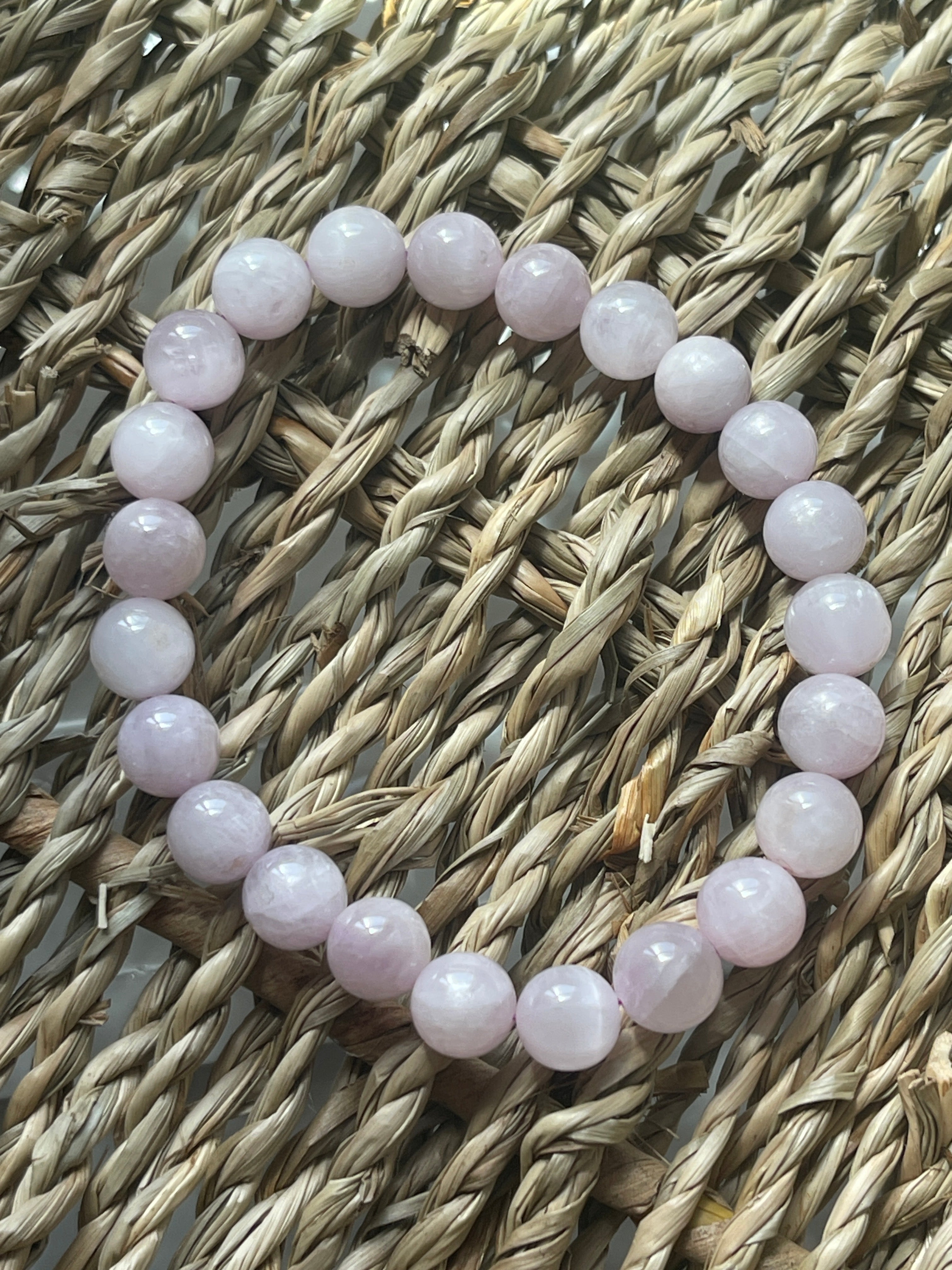 Pink beaded bracelet on a woven surface Kunzite Bracelet Florida at Pure Energy Crystals 