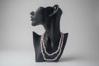 Black jewelry display with a Kunzite_Chip_Bead_Necklaces_30-32_Inches beaded necklace on a neutral background
