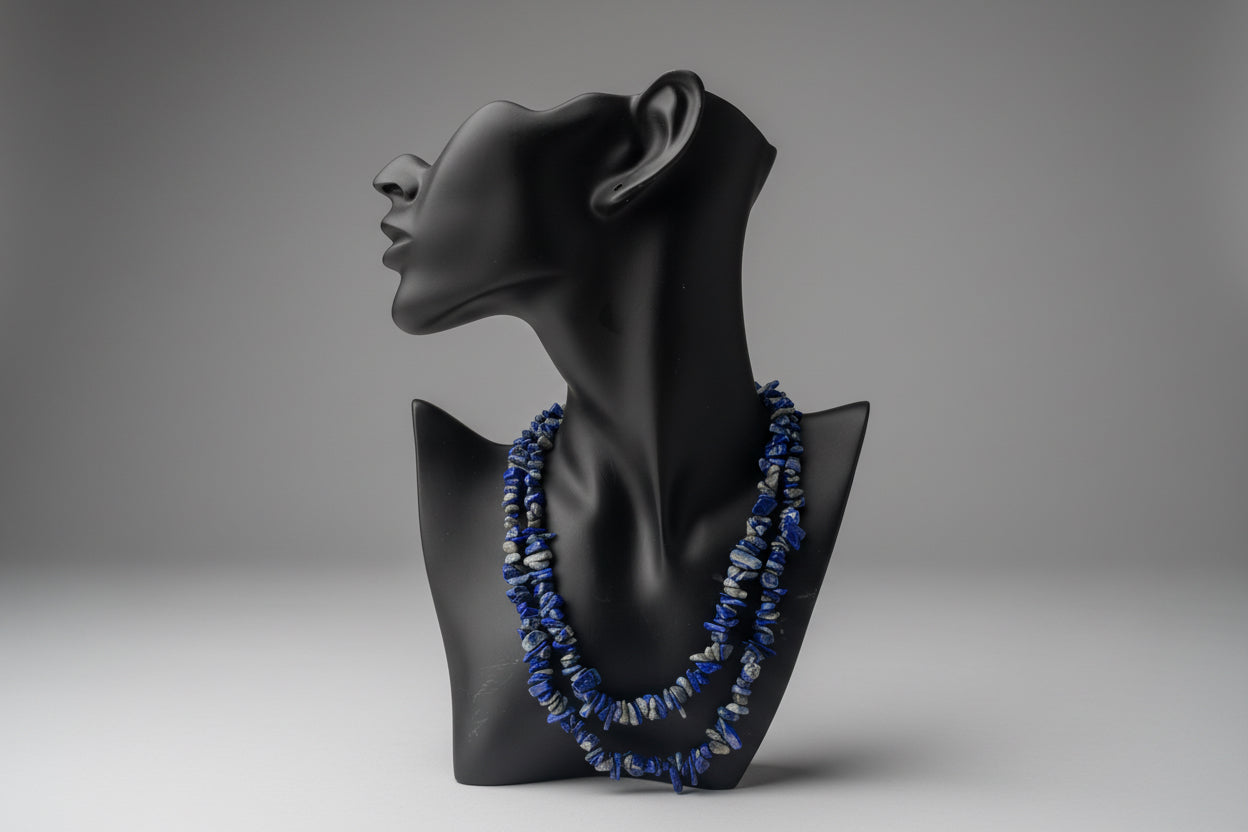 Black jewelry display with Lapis_Necklace blue beads on a mannequin against a window background