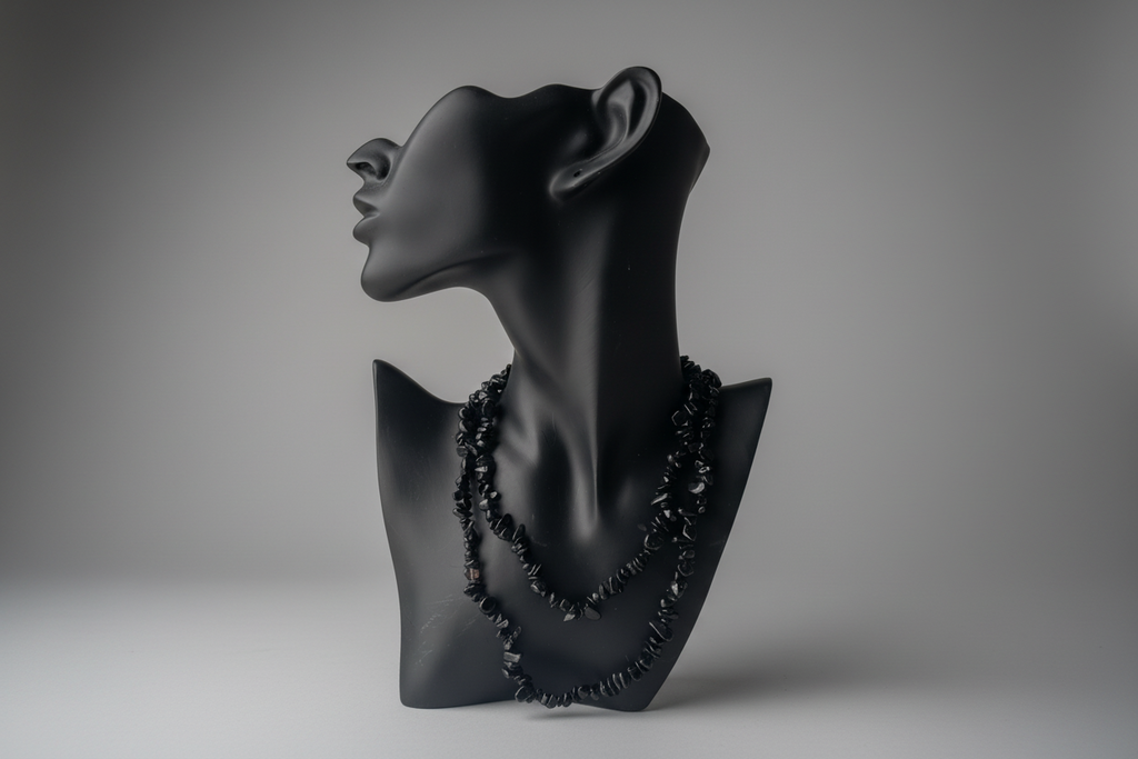 Black mixed obsidian chip beaded necklace on a black mannequin bust against a gray background