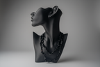 Black mixed obsidian chip beaded necklace on a black mannequin bust against a gray background