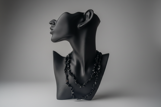 Black mixed obsidian chip beaded necklace on a black mannequin bust against a gray background