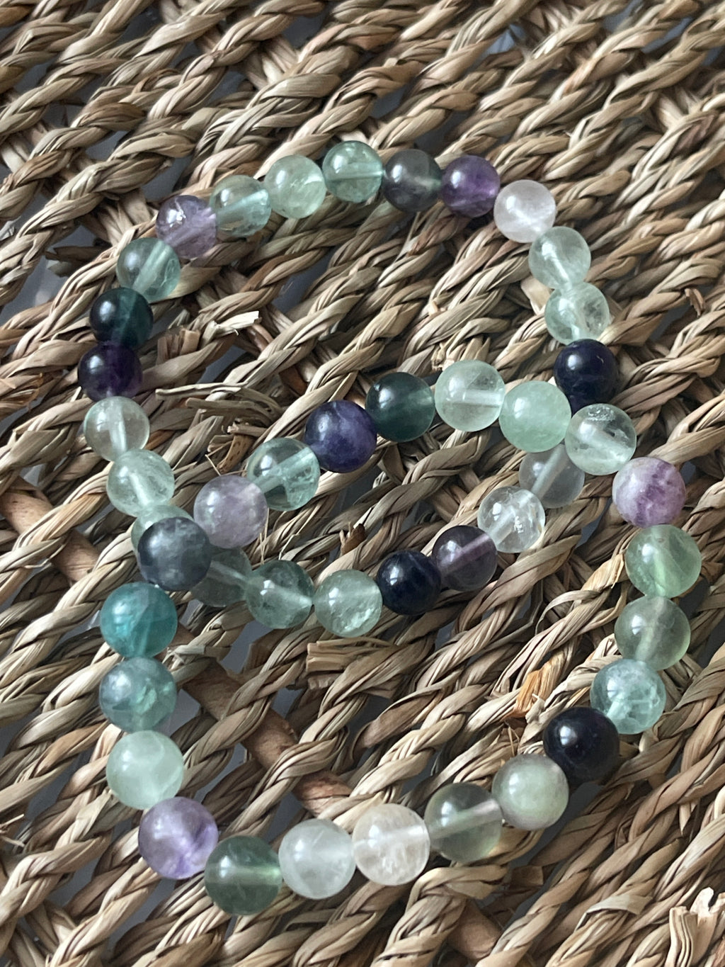 Multicolored beaded bracelets on a woven surface