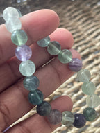 Multicolored beaded bracelet on a hand with a blurred natural background at pure energy crystals 