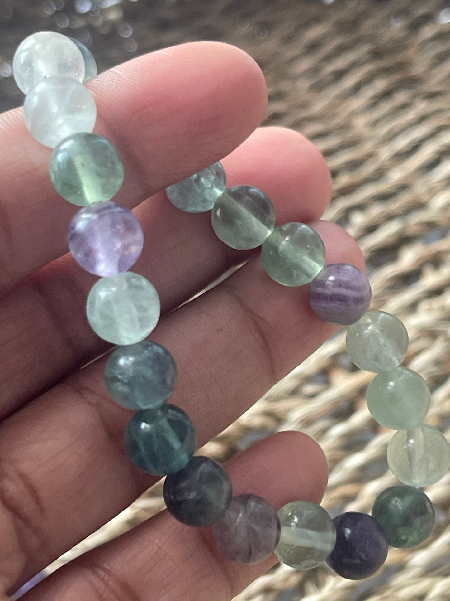 Multicolored beaded bracelet on a hand with a blurred natural background at pure energy crystals 