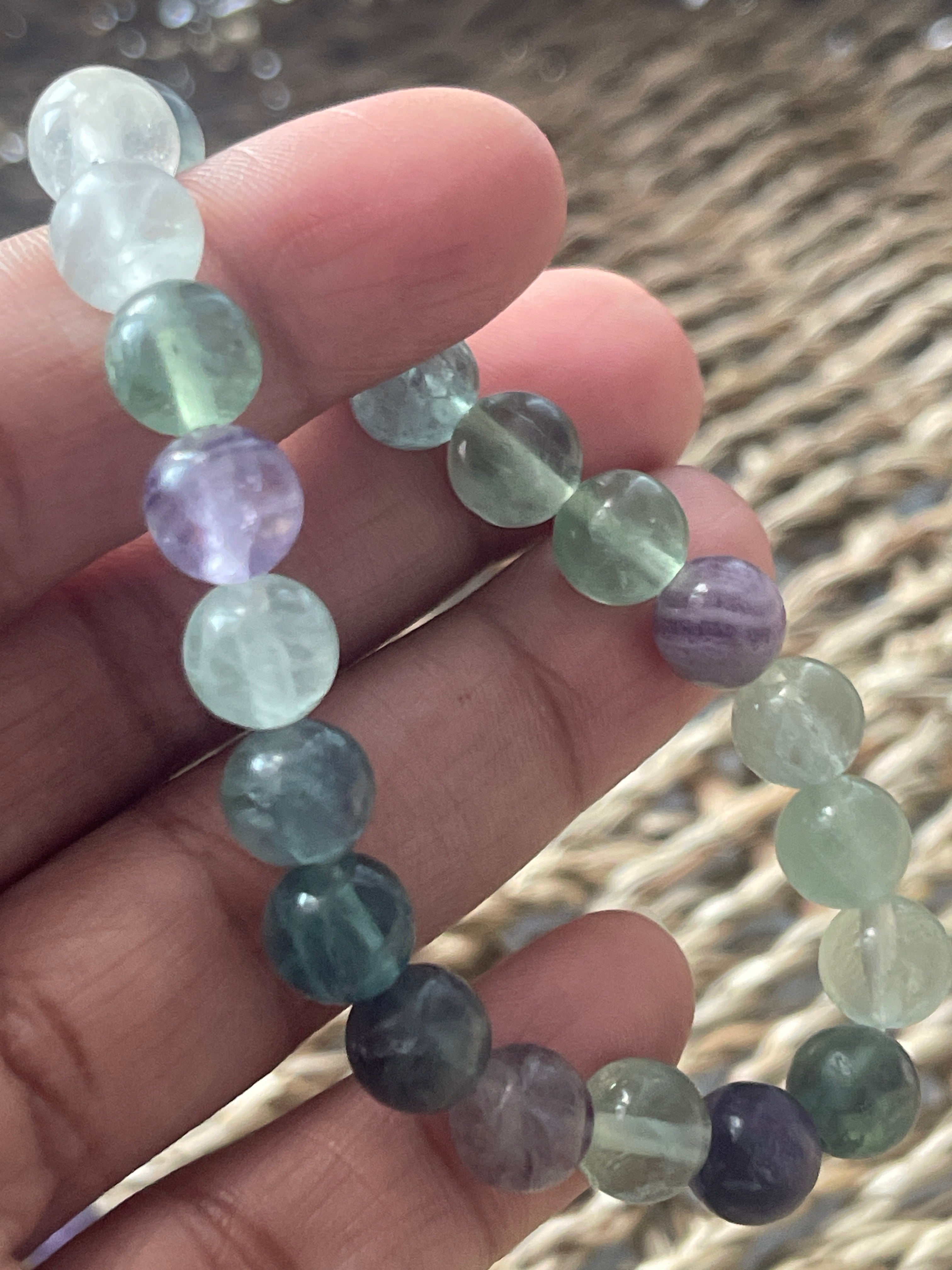 Multicolored beaded bracelet on a hand with a blurred natural background at pure energy crystals 