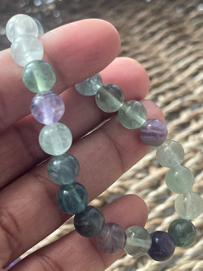 Multicolored beaded bracelet on a hand with a blurred natural background at pure energy crystals 