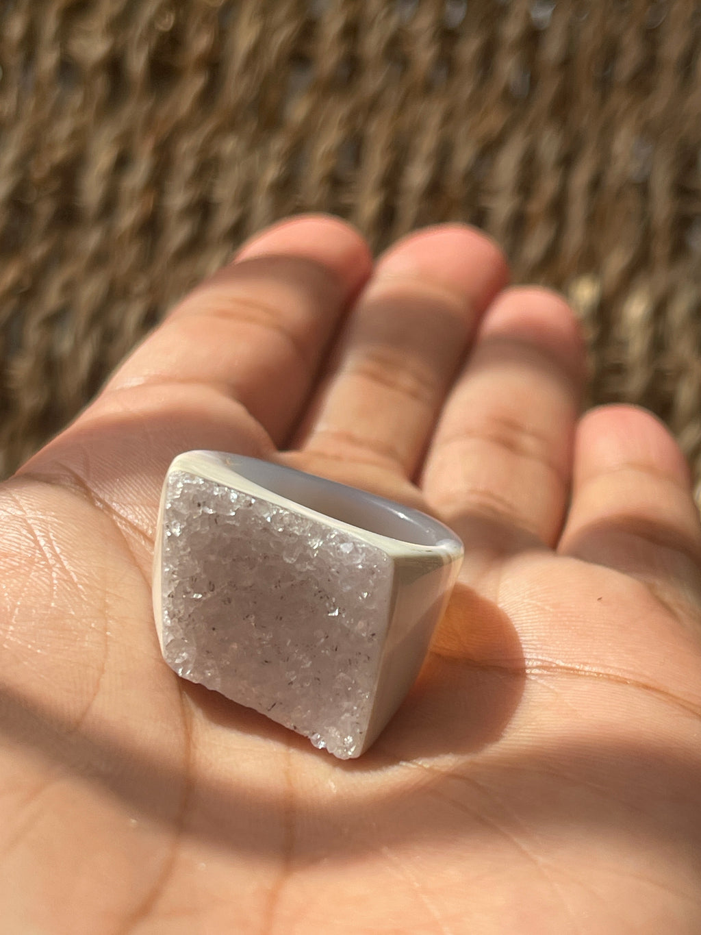Hand holding a square-shaped crystal with a textured surface against a blurred natural background Natural Agate Druzy Ring Pure Energy Crystals Florida