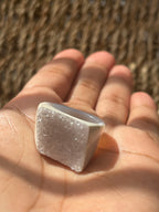 Hand holding a square-shaped crystal with a textured surface against a blurred natural background Natural Agate Druzy Ring Pure Energy Crystals Florida