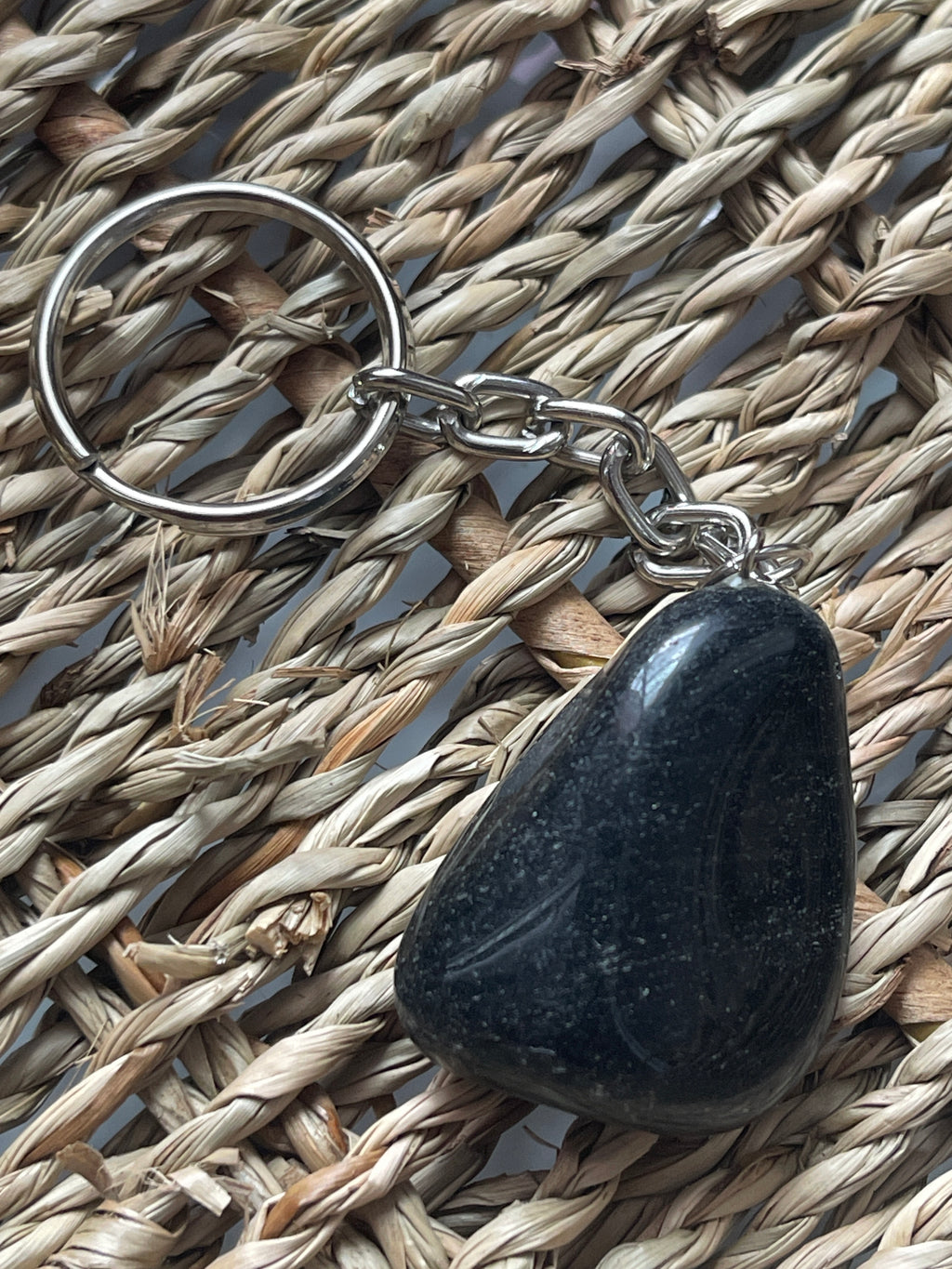 Obsidian Black stone keychain on a woven mat