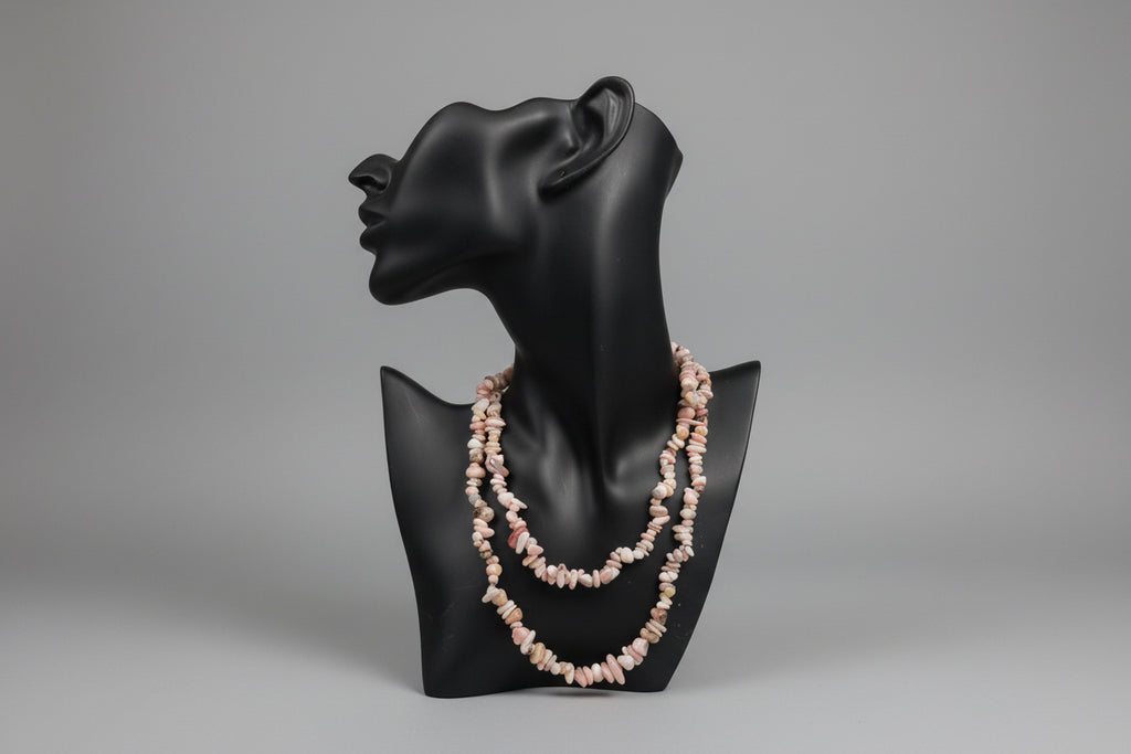 Pink_Opal_Necklace_30-32_Inches on a black jewelry stand with a blurred gray studio background 