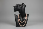 Pink_Opal_Necklace_30-32_Inches on a black jewelry stand with a blurred gray studio background 