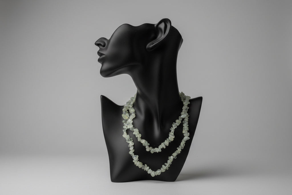 Black jewelry stand with a Prehnite_Chip_Necklace_30-32_Inches on a gray backdrop 