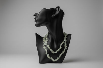 Black jewelry stand with a Prehnite_Chip_Necklace_30-32_Inches on a gray backdrop 