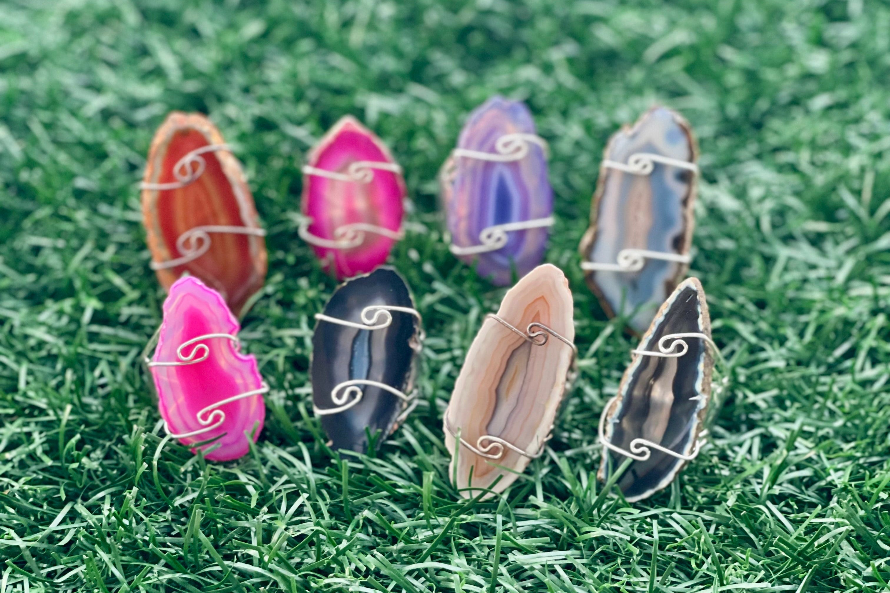 Set of colorful crystal stone agate rings on grass