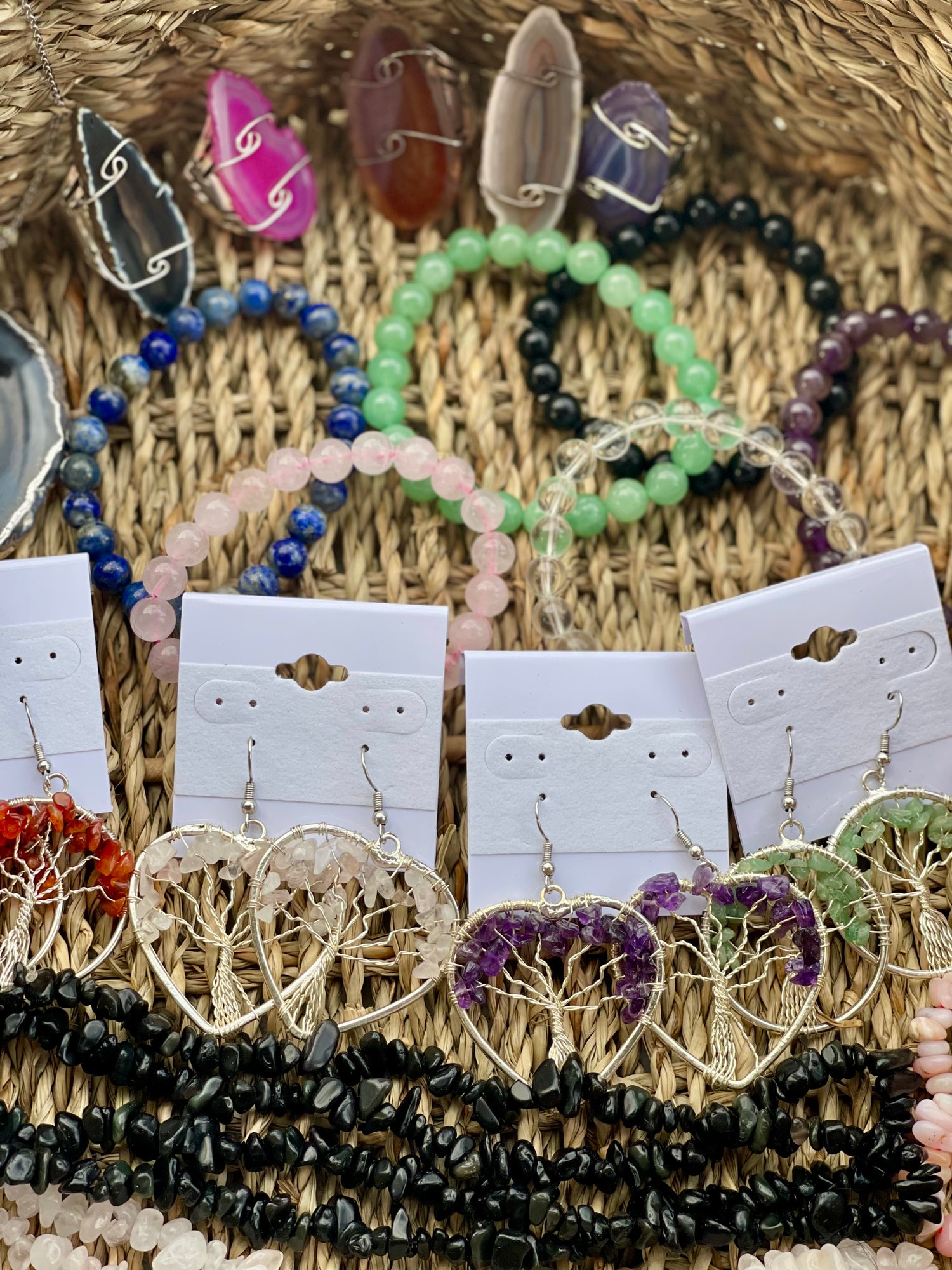 Assorted jewelry including earrings and bracelets on display cards against a textured background.