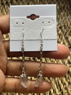 Quartz Crystal Spiral Earrings Silver plated earrings held by a hand against a textured background