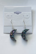 Rainbow Moon Amethyst Coated Earrings, Pair of glittery crescent moon earrings on a gray card.