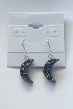 Rainbow Moon Amethyst Coated Earrings, Pair of glittery crescent moon earrings on a gray card.