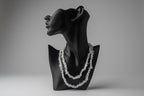  Black necklace display with decorative Rainbow_Moonstone_Necklace_30-32_Inches white stones with a gray backdrop in a studio 
