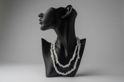  Black necklace display with decorative Rainbow_Moonstone_Necklace_30-32_Inches white stones with a gray backdrop in a studio 