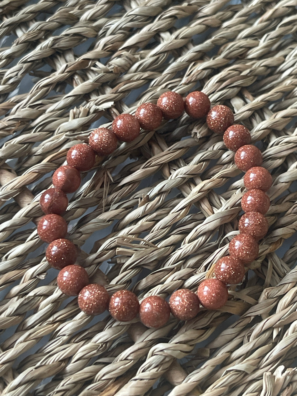 Red beaded bracelet on a textured woven surface