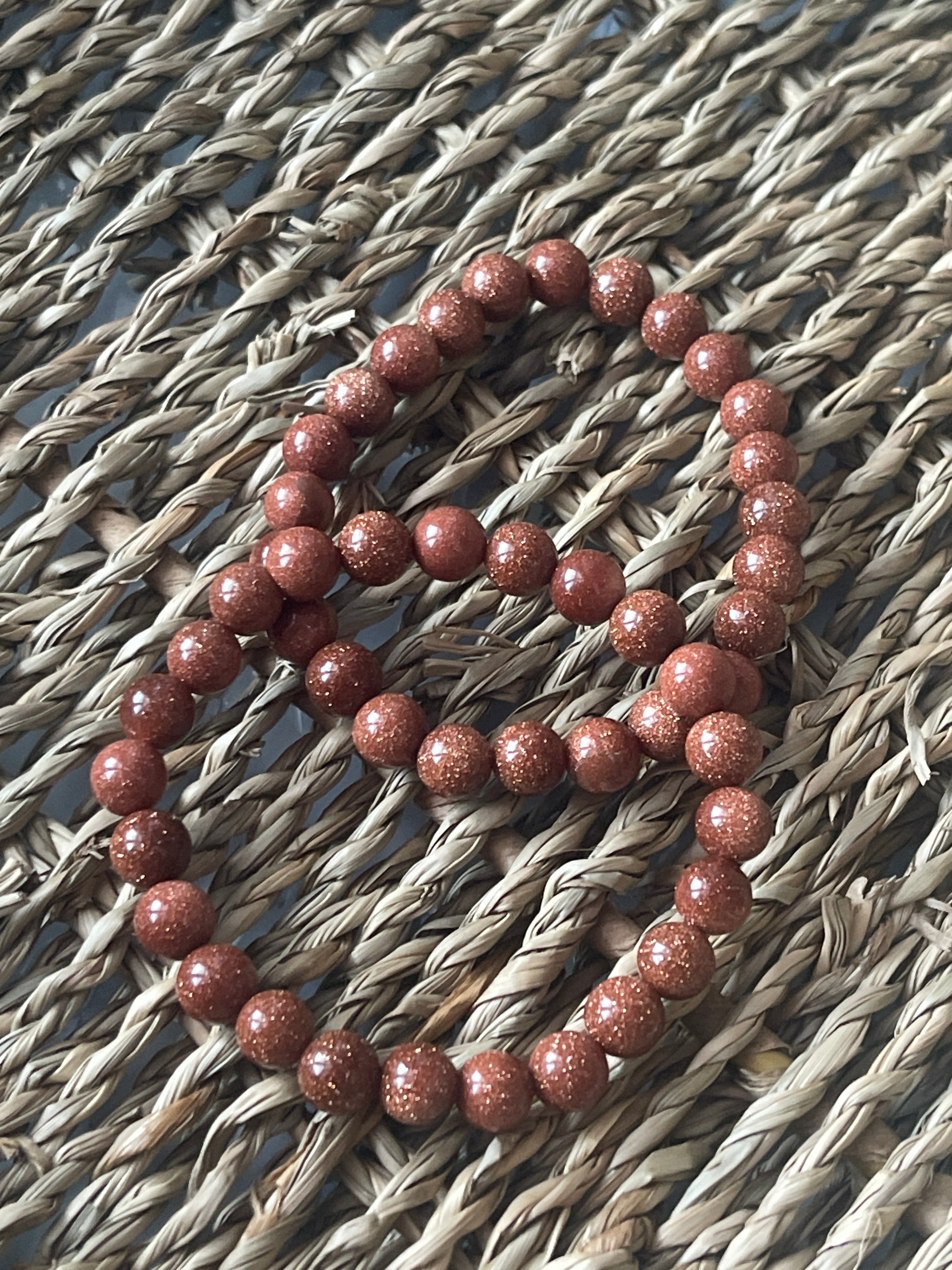 Red beaded bracelet on a textured woven surface
