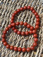 Red Jasper beaded bracelet on a woven surface