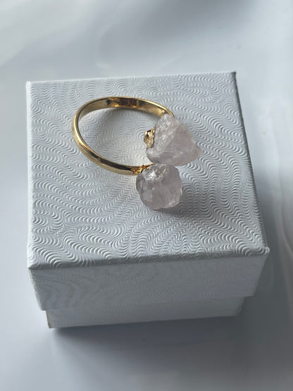 Rose quartz gold ring with pink crystals on a textured white jewelry box