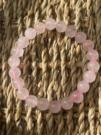 Bracelet with pink beads on a woven surface
