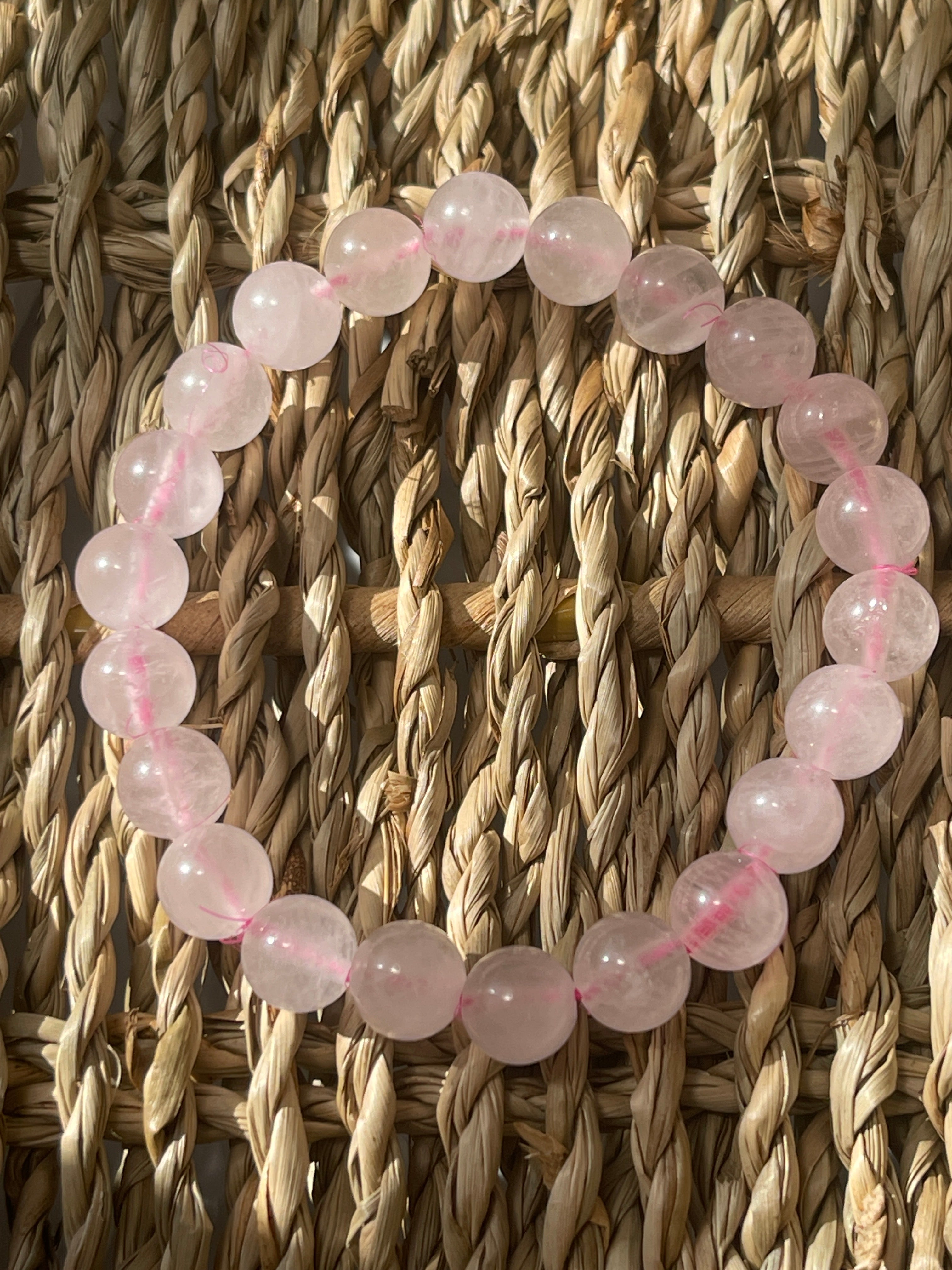 Bracelet with pink beads on a woven surface