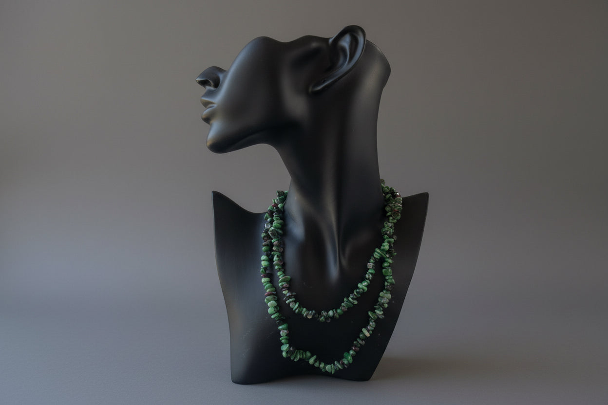 Black necklace display with Ruby Zoisite Necklace beads on a stand in a studio 