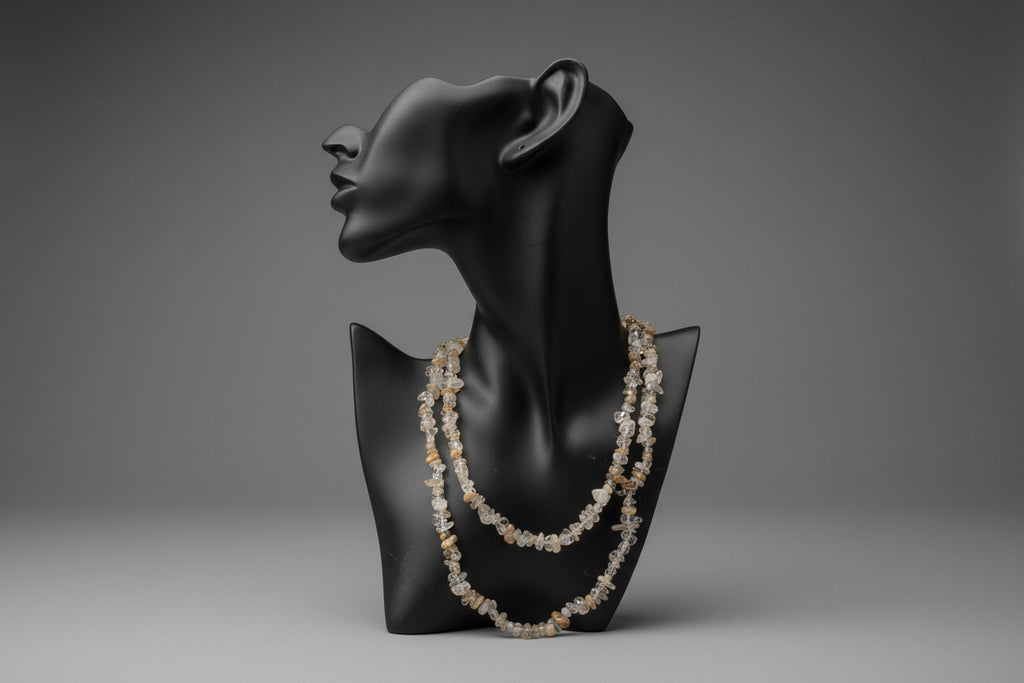 Black jewelry display with a Rutilated_Quartz_Necklace_30-32_Inches in a gray studio 