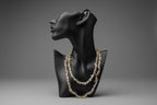 Black jewelry display with a Rutilated_Quartz_Necklace_30-32_Inches in a gray studio 