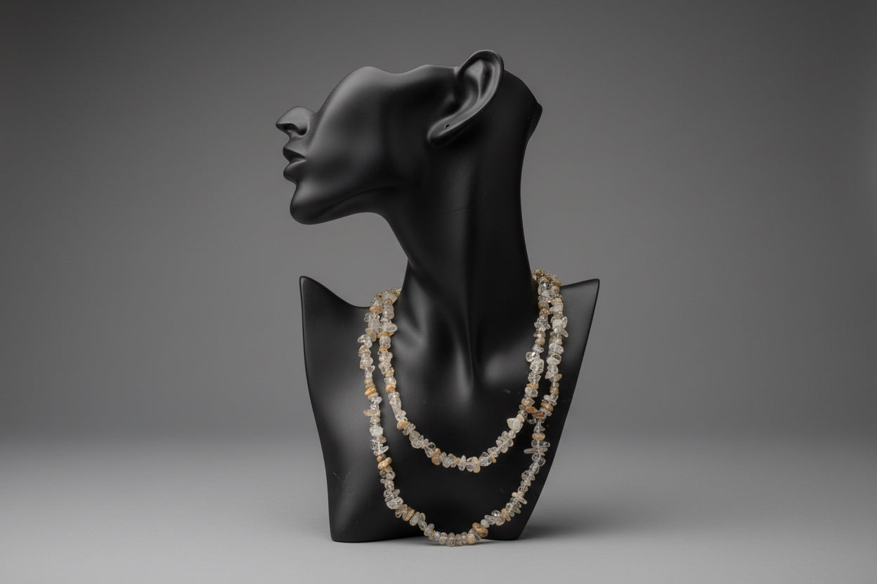 Black jewelry display with a Rutilated_Quartz_Necklace_30-32_Inches in a gray studio 
