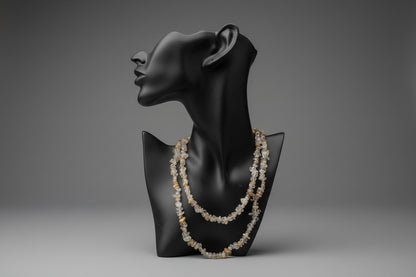 Black jewelry display with a Rutilated_Quartz_Necklace_30-32_Inches in a gray studio 