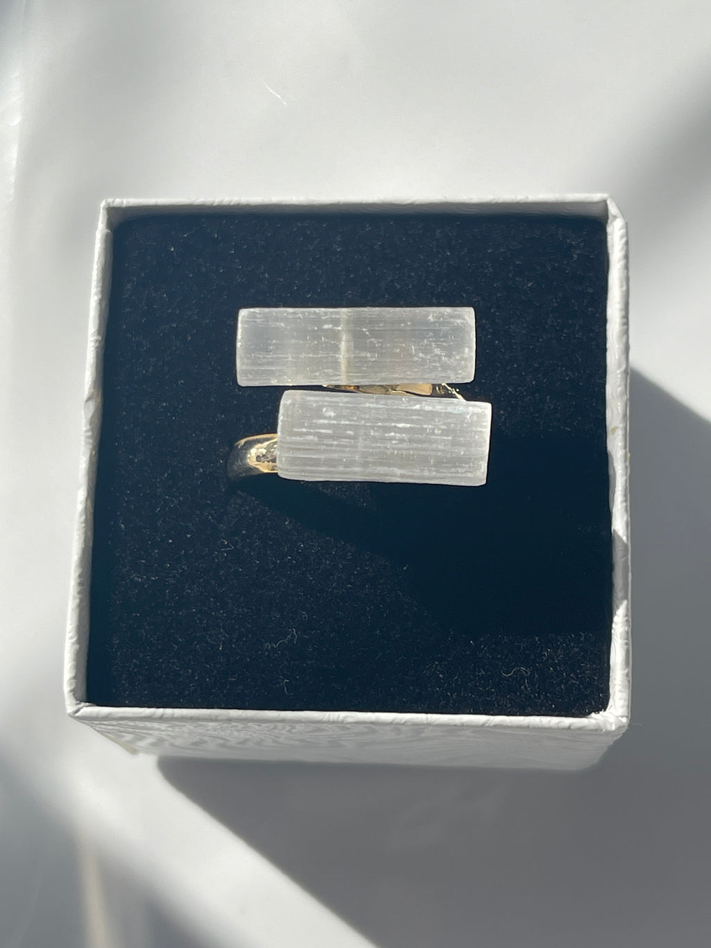 Gold plated selenite ring inside a white and black jewelry box in Florida
