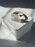 Selenite gold plated ring on a white jewelry box a textured white surface